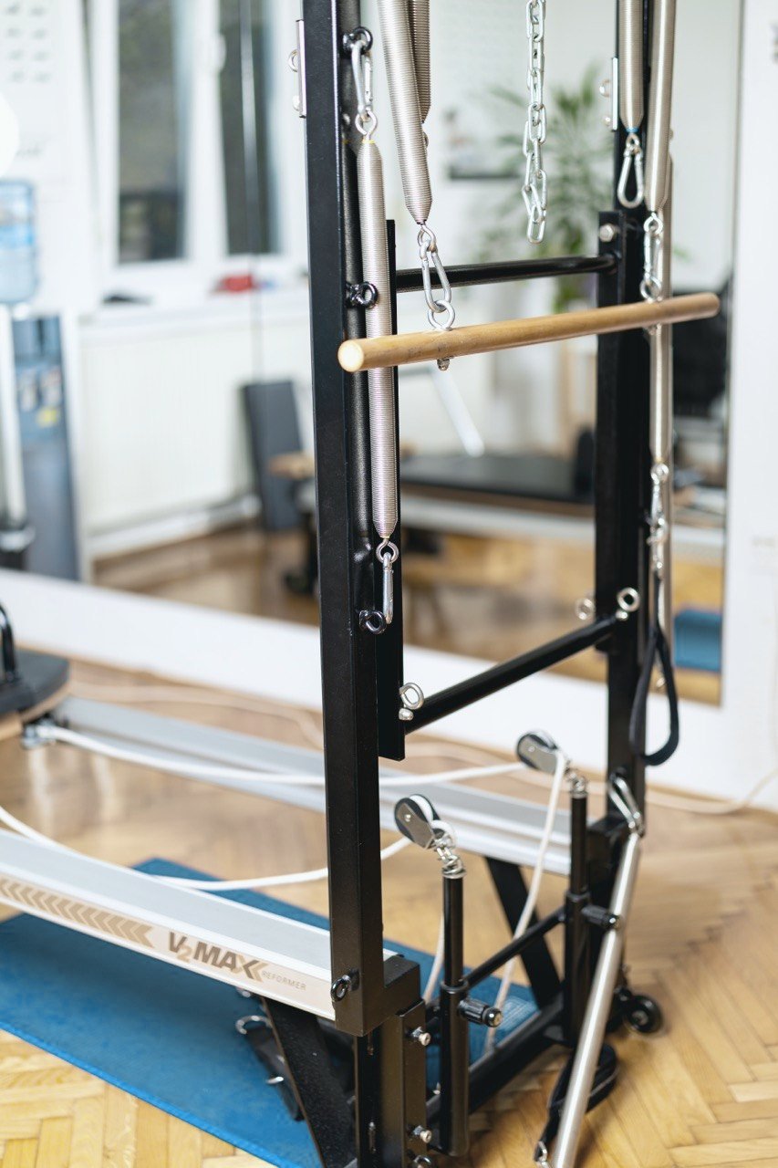 Reformer detail in the MATPilates studio — springs and wooden roll-up bar in natural light